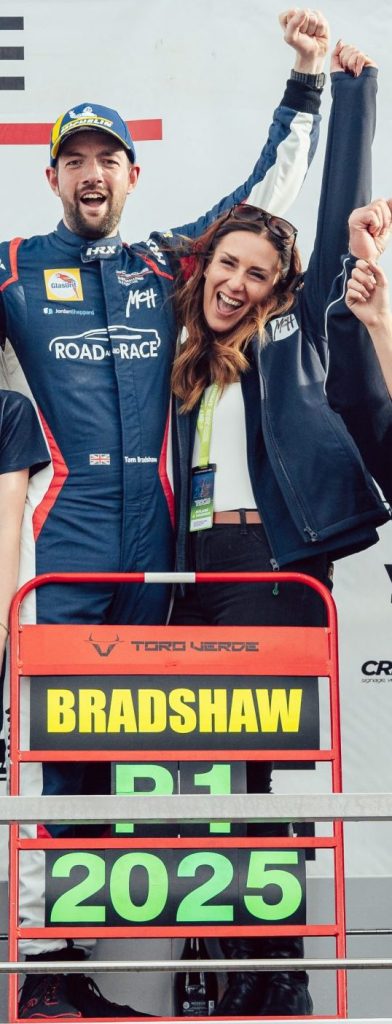 Tom Bradshaw and family standing on the podium at Brands Hatch celebrating his winning the Porsche Sprint Challenge GB Championship 2025